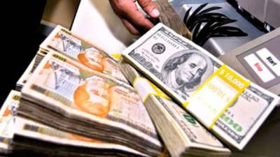 Imagen de archivo que muestra dinero en efectivo. Billetes de 100 lempiras y 100 dólares.