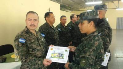 Autoridades de la Policía Militar de Orden Público hacen entrega de los certificados de graduación.