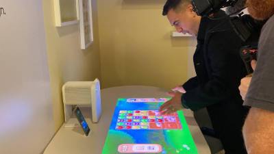 Un usuario se divierte con un juego que se proyecta en una mesa con The Premiere 5, en el evento First Look, de Samsung.