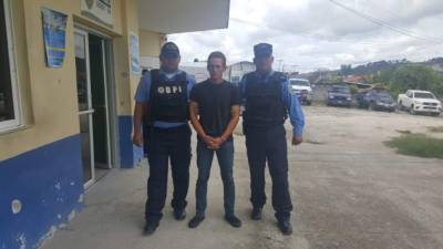 El detenido Juan Yonatan Miranda, custodiado por agentes de la DPI tras su captura.