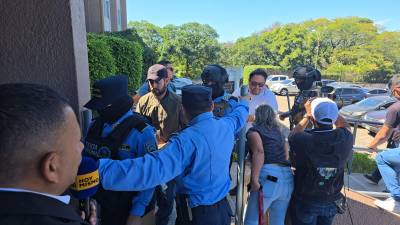 Los implicados siendo resguardados por policías tras las detenciones.