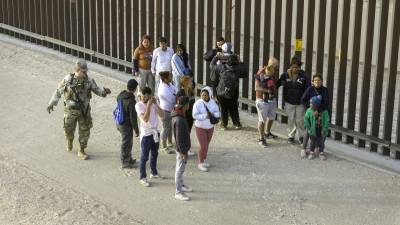 Un grupo de migrantes es vigilado por la Guardia Nacional tras ingresar a Texas.