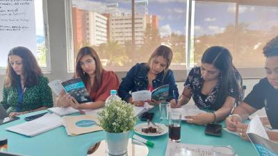 Personal de Dinaf leyendo el folleto ofrecido por la Cicesct durante la capacitación.