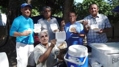 Ricardo Rodríguez, junto a clientes y amigos de la Mensajeros de la Paz, muestra las burritas que elabora. Fotos: José Cantarero