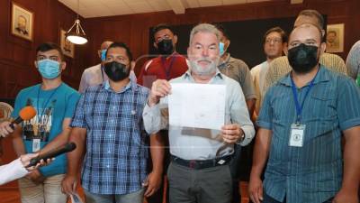 El alcalde Roberto Contreras muestra el documento firmado. Representantes del rubro de lavadores de carro acompañaron la firma.