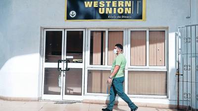 Una persona se acerca a una agencia a retirar remesas.