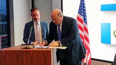 Jorge Canahuati y Eugenio Sosa Mendoza firman el acuerdo en Washington.