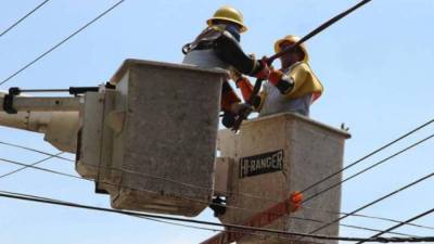 Trabajadoras de la Enee hacen trabajos de mantenimiento.