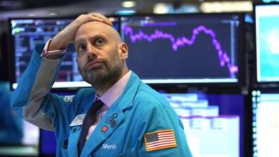 Un empleado reacciona a los datos del mercado que se exhiben en la Bolsa de Valores de Nueva York.