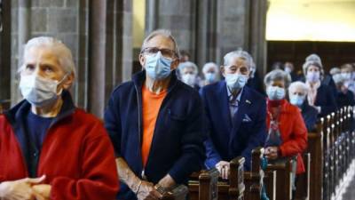 Devotos católicos asisten a la misa de la Catedral de Bolzano, este lunes en Italia. Italia, el primer país del mundo en declarar el confinamiento en todo su territorio por el coronavirus. EFE