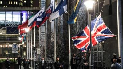 Los miembros del personal bajan hoy la bandera del Reino Unido desde fuera del edificio del Parlamento Europeo en Bruselas el Día del Brexit. AFP.