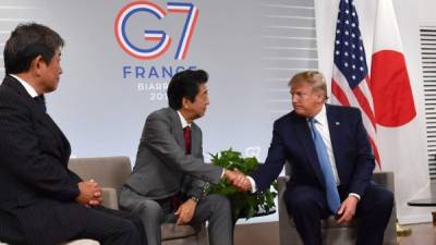 El presidente Trump y Shinzo Abe, primer ministro japonés, estrechan manos en la firma del acuerdo.