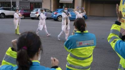 Médicos españoles son aplaudidos a las afueras de un hospital.