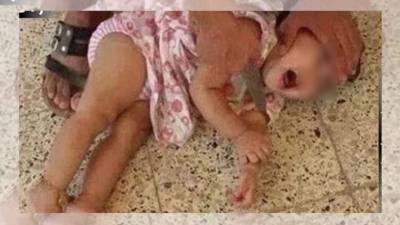 La fotografia muestra a la menor llorando desesperadamente, mientras uno de los terroristas sostiene un cuchillo en su garganta.