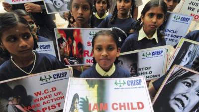 Varias huérfanas de la ONG 'Iniciativa de los Derechos del Niño para la Participación Conjunta en la Vida Familiar' sostienen carteles durante una protesta silenciosa contra el acoso sexual a los niños en Bangalore.