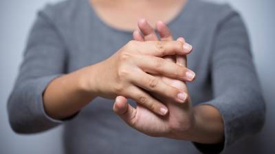 Una mujer estirando sus manos como parte de un ejercicio para combatir la artritis.