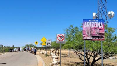 Un grupo de personas participan de la 'Caminata del migrante' durante su recorrido en Tucson, Arizona.