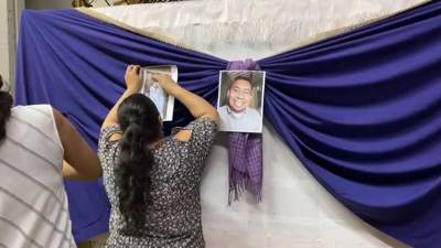Una feligrés coloca fotografías para recordar al sacerdote Enrique Vásquez.