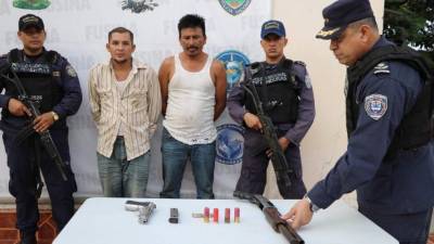 Los apresados junto a las armas decomisadas.