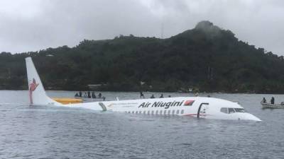 This photo taken by James Benito on September 28, 2018, shows locals approaching the crashed Air Niugini aircraft on the remote Island of Weno, in Micronesia.An Air Niugini plane ditched into a lagoon after overshooting the runway on the remote island of Weno but there were no serious injuries, local media reports said. / AFP PHOTO / JAMES BENITO / JAMES BENITO / RESTRICTED TO EDITORIAL USE - MANDATORY CREDIT 'AFP PHOTO / JAMES BENITO' - NO MARKETING NO ADVERTISING CAMPAIGNS - DISTRIBUTED AS A SERVICE TO CLIENTS == NO ARCHIVE