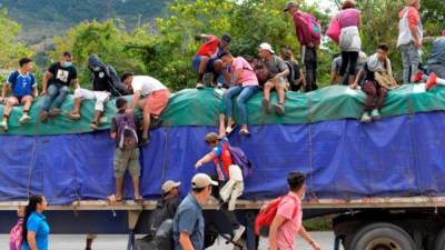 Los migrantes hondureños van de 'aventón' (autostop) por la carretera de Guatemala. AFP