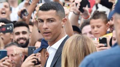 -FOTODELDIA- TUR12. TURIN (ITALIA), 16/07/2018.- Una multitud de aficionados recibe al portugués Cristiano Ronaldo a su llegada al J Medical, la clínica de propiedad del Juventus, para someterse al reconocimiento médico previo a la formalización de su fichaje por el conjunto turinés, en Turín (Italia), hoy, 16 de junio de 2018. Ronaldo se someterá a las pruebas médicas y si, como se espera, las supera, firmará un contrato de cuatro años con el Juventus, a cambio de cerca de 31 millones de euros netos por temporada. EFE/ Alessandro Di Marco