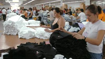 Mujeres doblan camisas en una maquila de la ciudad.