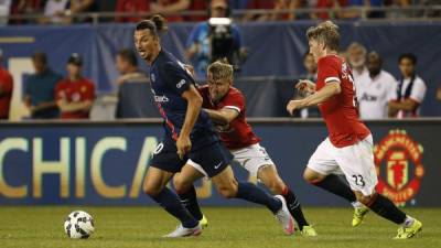 El delantero del PSG, Zlatan Ibramovic en posesión del balón contra dos del Manchester United.
