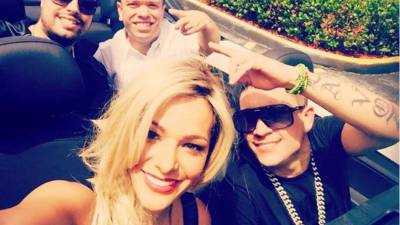 Con cabello rubio y vestido negro igual que la modelo del video original de Osmani. Jijijiji llegando en el taxi de Osmani Garcia, La Voz, El Gordo y La Flaca.