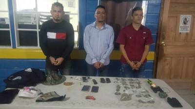 Los tres detenidos junto con lo decomisado en el momento de ser presentado ante las autoridades.