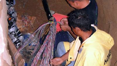 Técnicos de Hondutel de El Progreso y San Pedro Sula trabajan en la reparación de la red dañada.