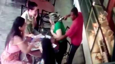 Un delincuente apunta en la cabeza a una mujer durante un asalto en la capital venezolana.