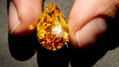 A Botswana member of cabinet holds a gem diamond in Gaborone, Botswana, on June 16, 2021. - Botswanan diamond firm Debswana said on June 16, 2021 it had unearthed a 1,098-carat stone that it described as the third largest of its kind in the world.The stone, found on June 1, 2021 was shown to President Mokgweetsi Masisi in the capital Gaborone. (Photo by Monirul Bhuiyan / AFP)