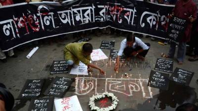 Activistas encienden velas en memoria de las vícticmas del ataque perpetrado en Bangladesh.