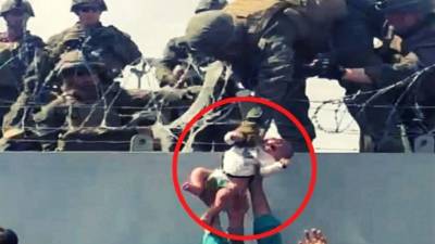 Se tornaron virales las imágenes de un bebé empujado con el brazo extendido por civiles hacia los soldados estadounidenses que se encuentran en el muro perimetral, protegiendo el aeropuerto de la capital afgana. Cortesía Omar Haidiri