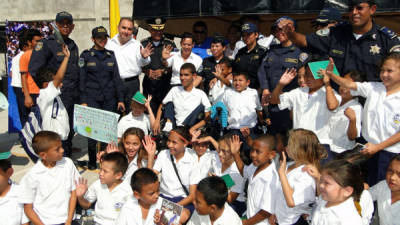 Autoridades policiales y municipales junto a niños de la escuela república de Alemania de la colonia Policarpo Paz García.