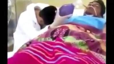 El doctor, no identificado, hincado al pie de una camilla bombeando aire manualmente a un paciente en el Hospital Escuela Universitario, el centro hospitalario público más importante de Honduras.
