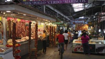 Personas mientras compran la carne y los mariscos en el mercado Dandy.