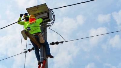 Trabajadores de la Enee haciendo labores de mantenimiento | Fotografía de archivo