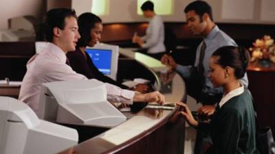 Personal de servicio al cliente atiende a cuentahabientes en una agencia bancaria de Alemania.