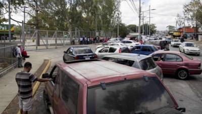 Decenas de personas, a pie y en vehículos particulares, esperan la apertura de las puertas de un supermercado este jueves, en Managua (Nicaragua). EFE/Jorge Torres
