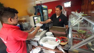 Un vendedor entrega la factura a su cliente.