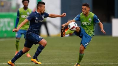Roger Espinoza marca el estadounidense Cristian Roldan, del Seattle Sounders. Foto AFP/Otto Greule Jr