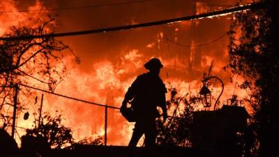 In this long exposure photograph, flames surround a drought-stricken Shasta Lake during the 'Salt fire' in Lakehead, California early on July 2, 2021, as firefighters battle nearly a dozen wildfires in the region following a heatwave and multiple lightning strikes. (Photo by JOSH EDELSON / AFP)