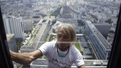 Alain Robert, el escalador urbano francés apodado Spiderman, escala los 210 m (689 pies) del rascacielos Tour Montparnasse en París.- AFP