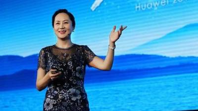 (FILES) In this file photo taken on August 2, 2019 people walk past a Huawei logo during the Consumer Electronics Expo in Beijing. - Huawei was hit February 13, 2020 with new US criminal charges alleging the Chinese tech giant engaged in a 'decades-long' effort to steal trade secrets from American companies.A US indictment unsealed in New York alleges Huawei conspired 'to misappropriate intellectual property' from six US firms as part of a strategy to grow its global business. (Photo by Fred DUFOUR / AFP)