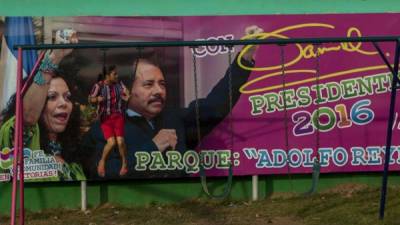 Una niña juega frente a un cartel con la imagen de la primera dama de Nicaragua, Rosario Murillo (i), junto al presidente de Nicaragua, Daniel Ortega (d), hoy, sábado 30 de julio de 2016, en el barrio Adolfo Reyes en el distrito 5 de Managua. EFE