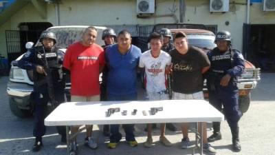 Los sospechosos con las evidencias encontradas, entre estas armas y dos carros, cuando fueron arrestados durante varios allanamientos el fin de semana.
