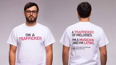 Uno de los activistas muestra el frente y revés de una de las camisetas de la campaña #TurnIgnoranceAround.