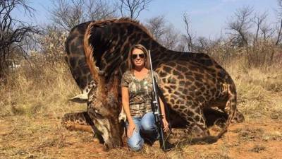 Tess Thompson Talley posando junto a su presa, una jirafa negra, un animal en peligro de extinción. Foto redes.